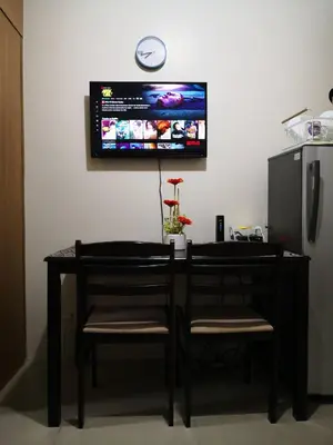 a dining room table with two chairs and a tv on the wall at Fancy Pasay City Apartment for Rent - Mall of Asia Nearby front of Mall Of Asia in Manila