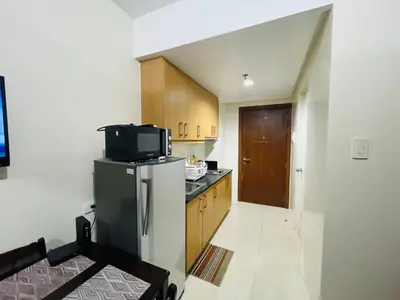 a small kitchen with a refrigerator and a microwave at Fancy Pasay City Apartment for Rent - Mall of Asia Nearby front of Mall Of Asia in Manila