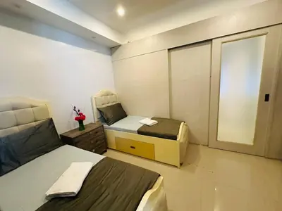 a small room with two beds and a window at Quaint 2BR Connected Apartment in Pasay City - Perfect for Families front of MOA in Manila