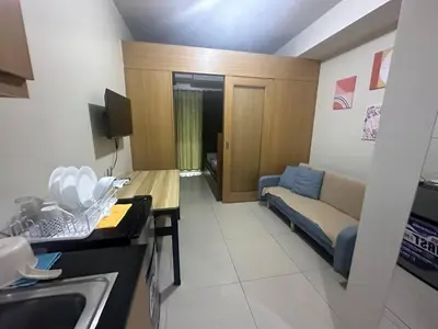 a small living room with a couch and a kitchen at Kempt Pasay City Apartment for Rent - Perfect for Short-Term Stay front of MOA in Manila