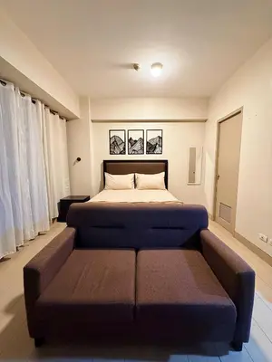 a bedroom with a bed and a couch in it at Kai cabins WALKING DISTANCE NAIA 3 AIRPORT NEWPORT CITY in Manila