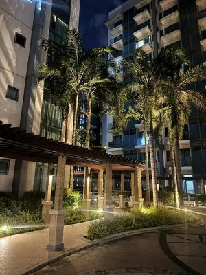 a building with palm trees in front of it at Kai cabins WALKING DISTANCE NAIA 3 AIRPORT NEWPORT CITY in Manila