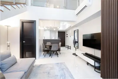 a living room with a couch and a television at BGC Spacious 1BR Loft Uptown in Manila