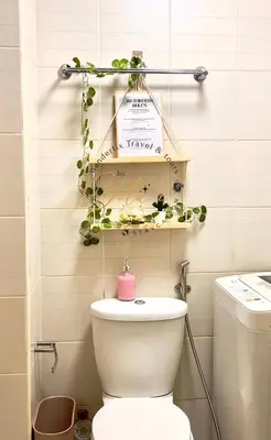 a bathroom with a toilet and a shelf with plants at Yola's Staycation - Jazz Residences Makati City in Manila