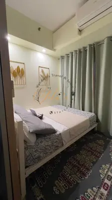 a bedroom with a bed in a room with curtains at Yola's Staycation - Jazz Residences Makati City in Manila