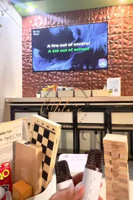 a person holding a wii remote in front of a tv at Yola's Staycation - Jazz Residences Makati City in Manila