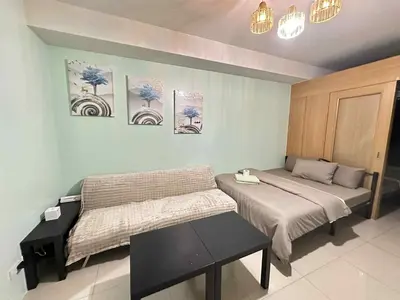 a bedroom with two beds and a table in it at Shell Residence Pasay MOA with 2 Beds by G&K in Manila