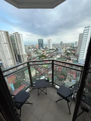 a balcony with chairs and a view of a city at 1-Bedroom Condo - Stunning Sunset at the City in Manila