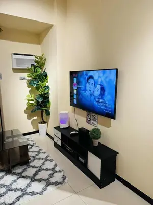 a living room with a flat screen tv on a wall at 1-Bedroom Condo - Stunning Sunset at the City in Manila