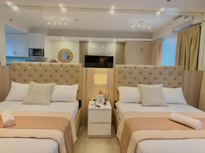 a bedroom with two beds and a table with a lamp at Le Luna Unit - Affordable Staycation near Airport & MOA with pool by Voyage Vista - Azure & Shore Staycation in Manila