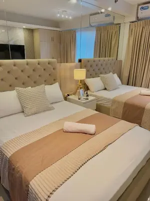 a bedroom with two beds and a lamp at Le Luna Unit - Affordable Staycation near Airport & MOA with pool by Voyage Vista - Azure & Shore Staycation in Manila