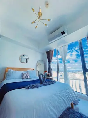 a bedroom with a large bed with a swan on it at Staycation in Marymount in Manila