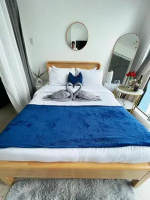 a bedroom with a bed with a blue blanket at Staycation in Marymount in Manila