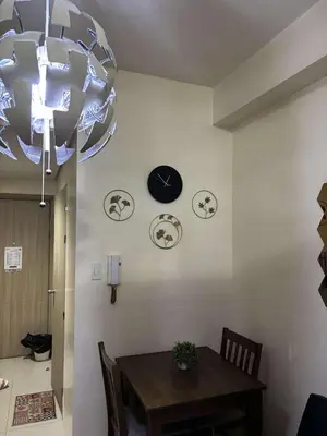a dining room with a table and a clock on the wall at Seaside Stay in Manila