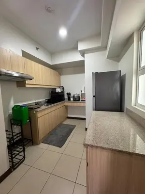 a large kitchen with a black refrigerator in it at J Suite in Manila