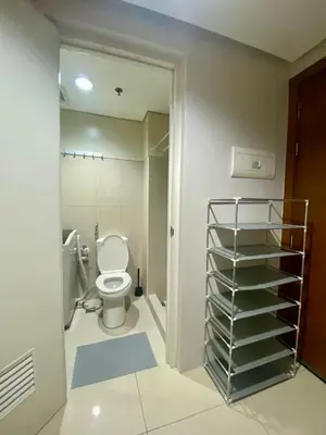 a bathroom with a toilet and a towel rack at Cousins' Haven Staycation at SHELL RESIDENCES near MOA and NAIA in Manila