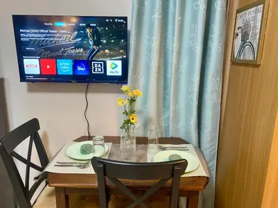 a dining room table with a television and a table and chairs at Cousins' Haven Staycation at SHELL RESIDENCES near MOA and NAIA in Manila