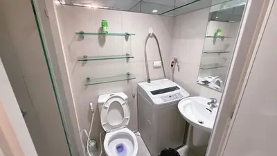 a small bathroom with a toilet and a sink at Staycapades at Shell Residences in Manila