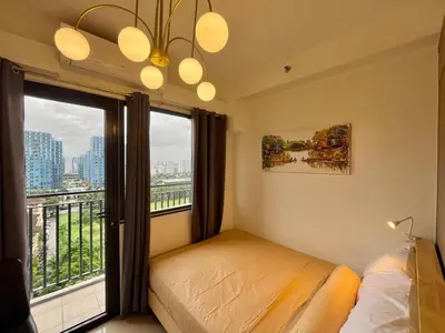 a bedroom with a bed and a large window at Liwayway Suites in Manila