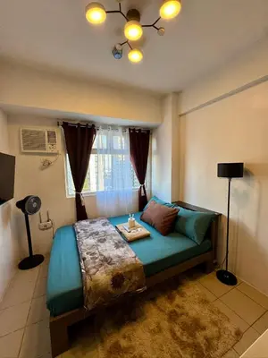 a bedroom with a bed and a window at PaulBert's Cabins II in Sampong