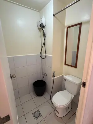 a small bathroom with a toilet and a mirror at PaulBert's Cabins II in Sampong