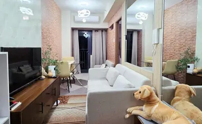 a living room with a dog laying on a couch at Luxe Vintage with Best View MallofAsia Airport in Manila