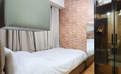 a small bedroom with a bed and a brick wall at Luxe Vintage with Best View MallofAsia Airport in Manila