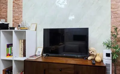 a teddy bear sitting next to a large television at Luxe Vintage with Best View MallofAsia Airport in Manila