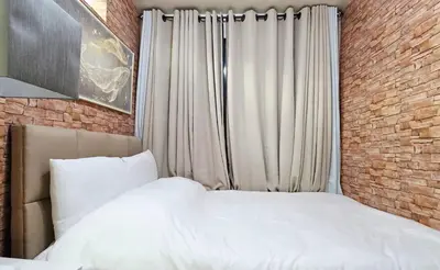 a bedroom with a white bed and a brick wall at Luxe Vintage with Best View MallofAsia Airport in Manila
