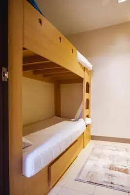 a bunk bed in a small room with a ladder at Luxury Condo at Bayshore Residential Phase 2 beside OKADA & near MOA in Manila