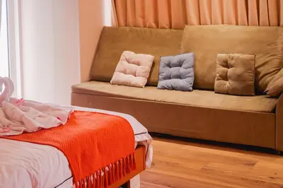 a couch with two pillows on it in a room at Luxury Condo at Bayshore Residential Phase 2 beside OKADA & near MOA in Manila