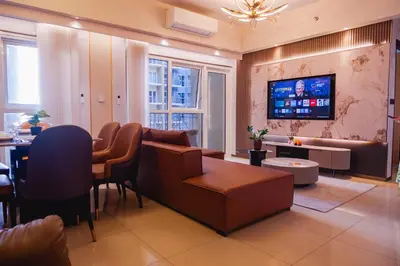a living room with a couch and a tv at Luxury Condo at Bayshore Residential Phase 2 beside OKADA & near MOA in Manila