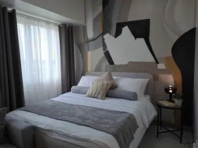 a bedroom with a large bed with pillows on it at Homey Roxas Blvd Condo Pool Parking WiFi in Manila