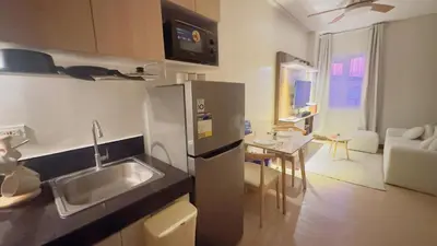 a kitchen with a stainless steel refrigerator and a table at Resort Condo in Trece Martires Cavite in Trece Martires
