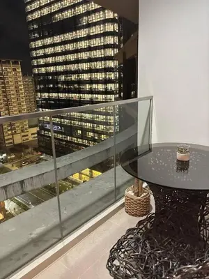 a glass table on a balcony with a view of a city at BGC Premium 1BR with Balcony fast 600 mbps Fibre in Manila