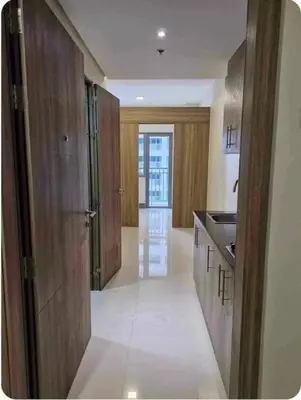a large kitchen with wooden cabinets and a hallway at Condo unit for rent in Manila