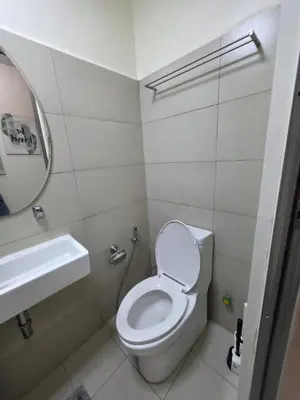 a small bathroom with a toilet and a sink at Staycation in Oasis in Manila