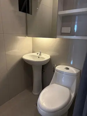 a white bathroom with a toilet and a sink at 3BR golf view in fort victoria BGC in Manila