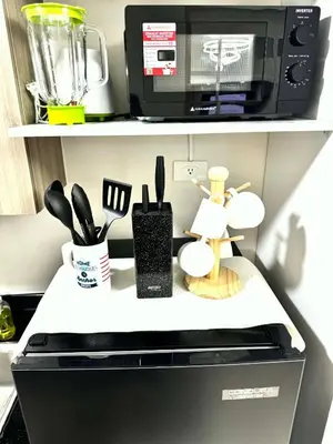 a kitchen counter with a microwave and some kitchen utensils at JB Urban Nest at SMDC Fame Residences in Manila