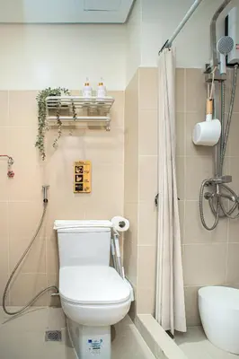 a bathroom with a toilet and a shower at Boho Makati Condo w/ Wi-Fi + Workspace | Red in Manila