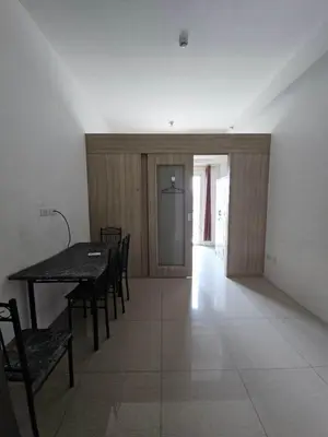 a dining room with a table and chairs and a hallway at Shore 1 Residences Tower D in Manila
