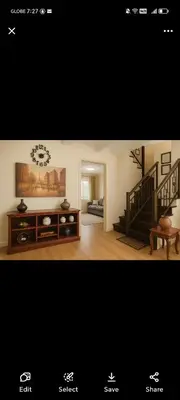a living room with a staircase and a living room with a table at David home in Manila