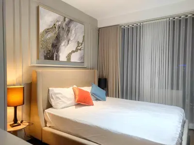 a hotel room with a bed with a window and a picture at Elegant Stylish 1 Bedroom Balcony City and Manila Bay view FREE Sauna Pool GYM Makati in Manila