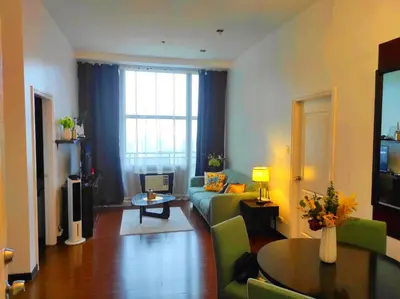 a living room with a couch and a table at Big NEW 1 Bedroom corner unit with Balconies - FREE Sauna Pool Gym View of Skyline, Manila Bay, Sunset in Manila