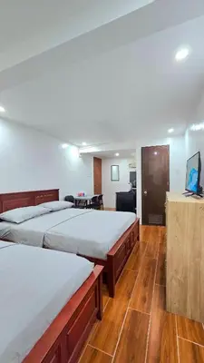 two beds in a room with wooden floors at Studio Units near Airport by Jade Studio Apartments in Manila