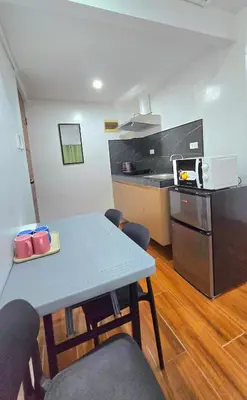 a kitchen with a table and chairs and a microwave at Studio Units near Airport by Jade Studio Apartments in Manila