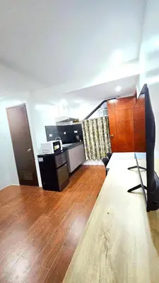 a living room with a television on a wooden floor at Studio Units near Airport by Jade Studio Apartments in Manila