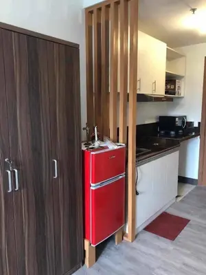 a kitchen with a red refrigerator and wooden cabinets at Staycation at CJS in Manila