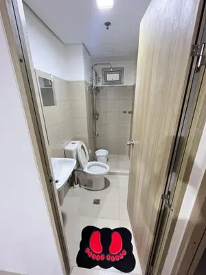 a bathroom with a toilet and a sink and a door at Bahay Pahuway in Manila