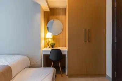a bedroom with a bed and a desk and a mirror at Spacious 3 BR in Uptown Parksuites, BGC Fast Wi Fi Washer in Manila